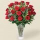 florero de rosas rojas en jarron de cristal con follajes 